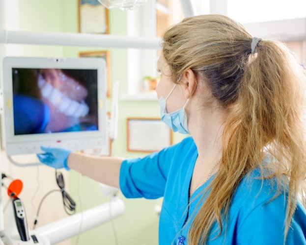 Dental team member looking at smile images taken by intraoral camera