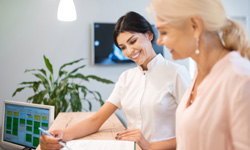 Smiling dental assistant showing patient forms