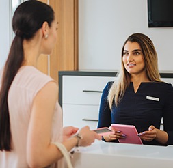 Dental team member and patient reviewing dental insurance