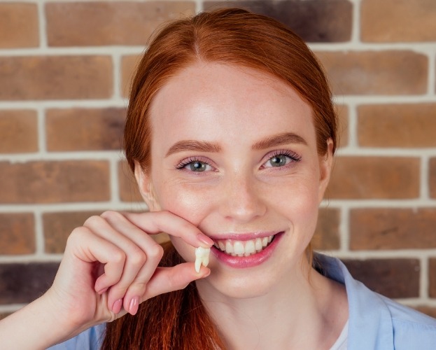 Woman holding tooth after extraction