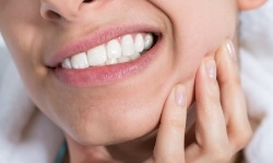 Closeup of patient with toothache holding jaw