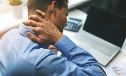 Man with neck pain holding his neck