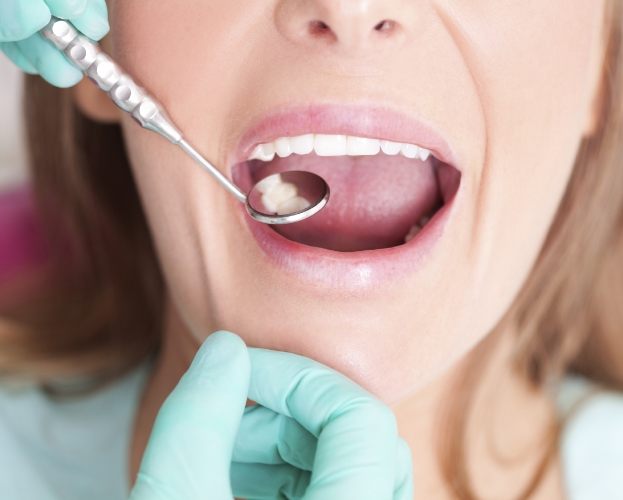 Dentist examining smile after tooth colored fillings