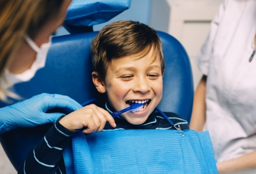 Young boy practicing tooth brushing during children's dentistry visit