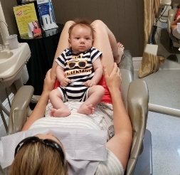 Woman holding baby during first children's dentistry visit