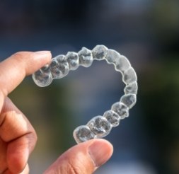 Hand holding an Invisalign tray