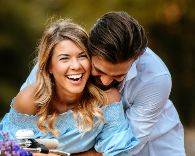 Woman with flawless smile after zirconia dental implant tooth replacement