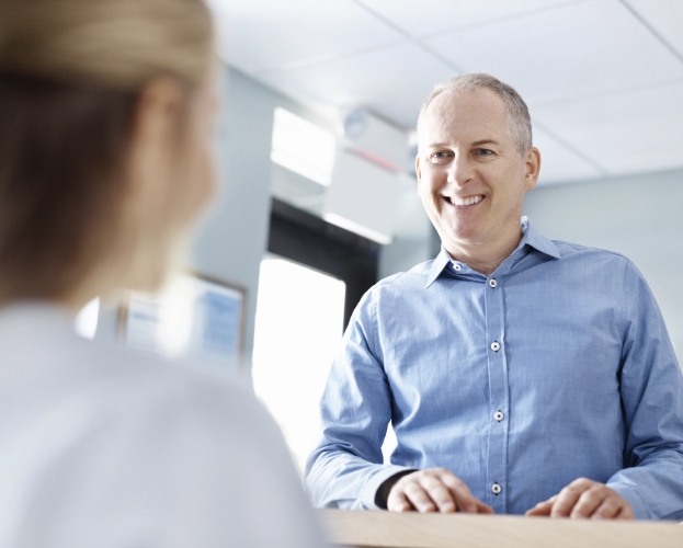 Man talking to dental team member about dental insurance coverage