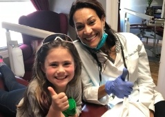 Dentist and young patient taking a picture together in treatment room