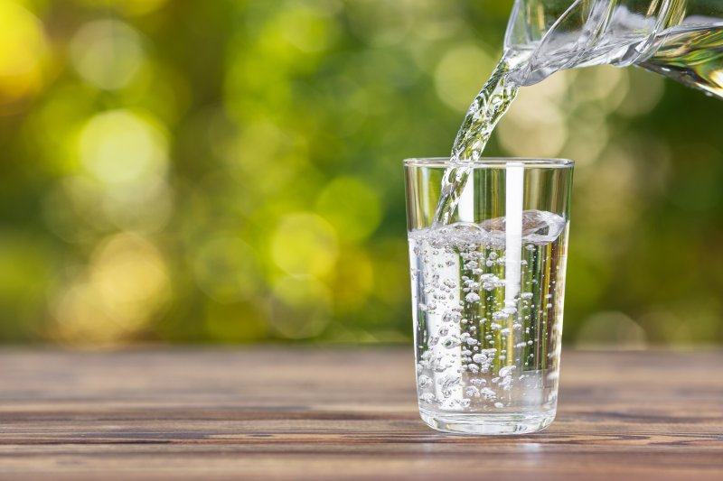 pouring water in clear glass