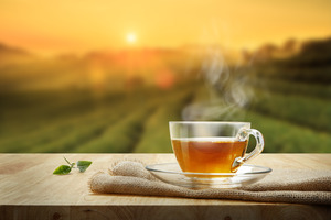 Cup of hot tea on towel on table