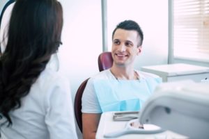 Smiling male patient talking with dentist