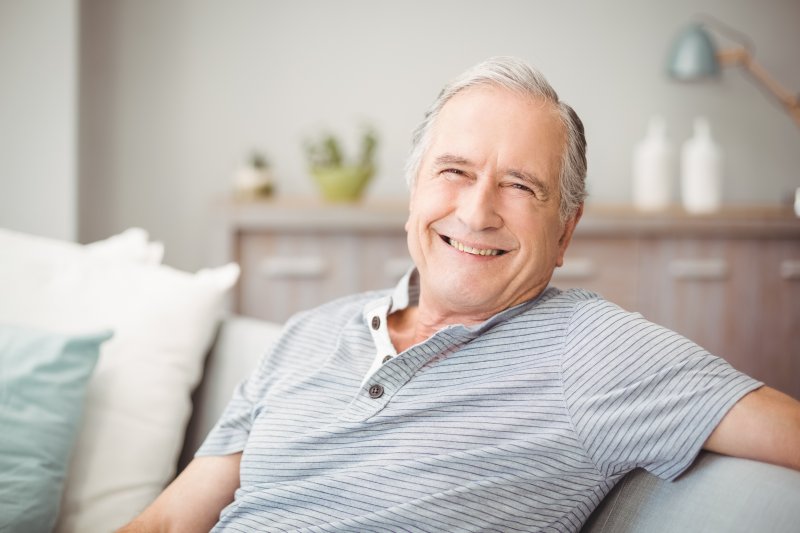 older man smiling while on the couch